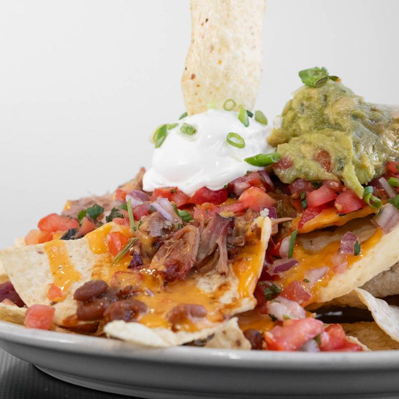 Lester's BBQ nachos with smoked pork, guacamole, pico de gallo and sour cream