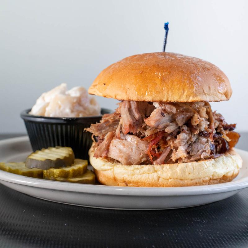 Lester's pulled pork sandwich with pickles and potato salad